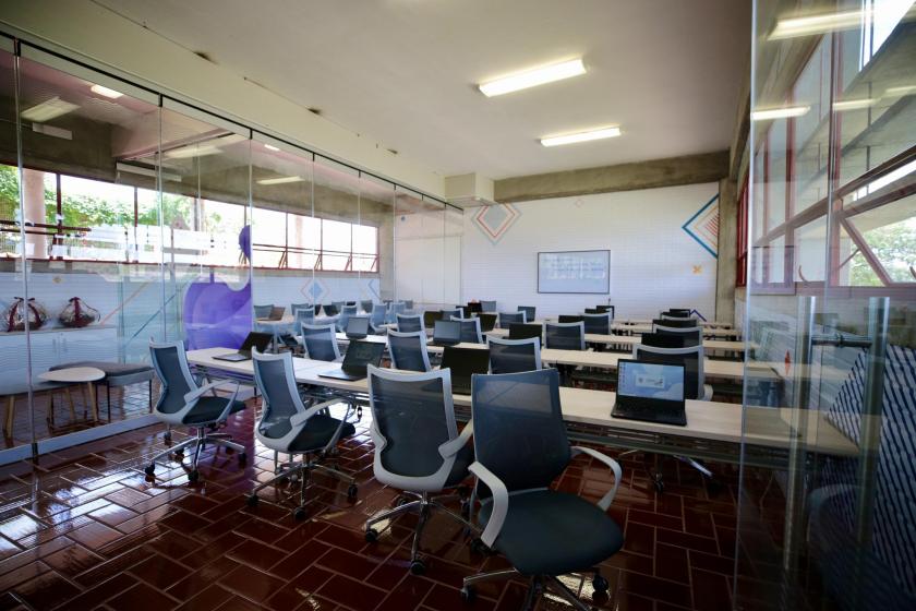 Salón con una serie de escritorios y sillas.