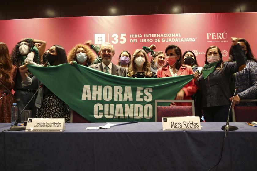 Panelistas del panel “Derecho a decidir” sosteniendo una tela en la que se lee "AHORA ES CUANDO".