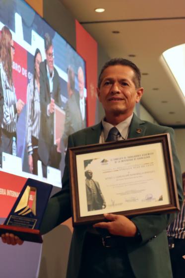 Trabajador académico con su reconocimiento.