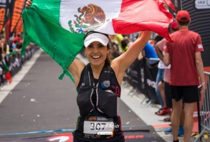 Mujer sosteniendo la bandera de México sobre su cabeza.